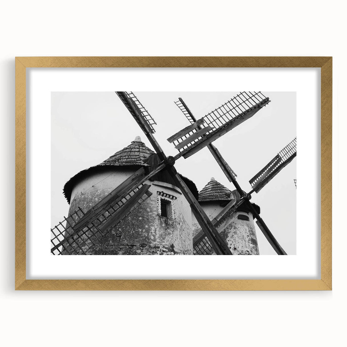 Framed wall art depicting a serene landscape with windmills, featuring a gold mat and elegant frame, ideal for home decor and enhancing interior aesthetics.