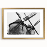 Framed wall art depicting a serene landscape with windmills, featuring a gold mat and elegant frame, ideal for home decor and enhancing interior aesthetics.