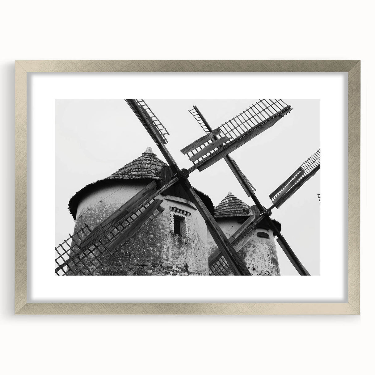 Framed wall art featuring a picturesque landscape with windmills, showcasing a silver mat and frame in a contemporary design, perfect for home decor.