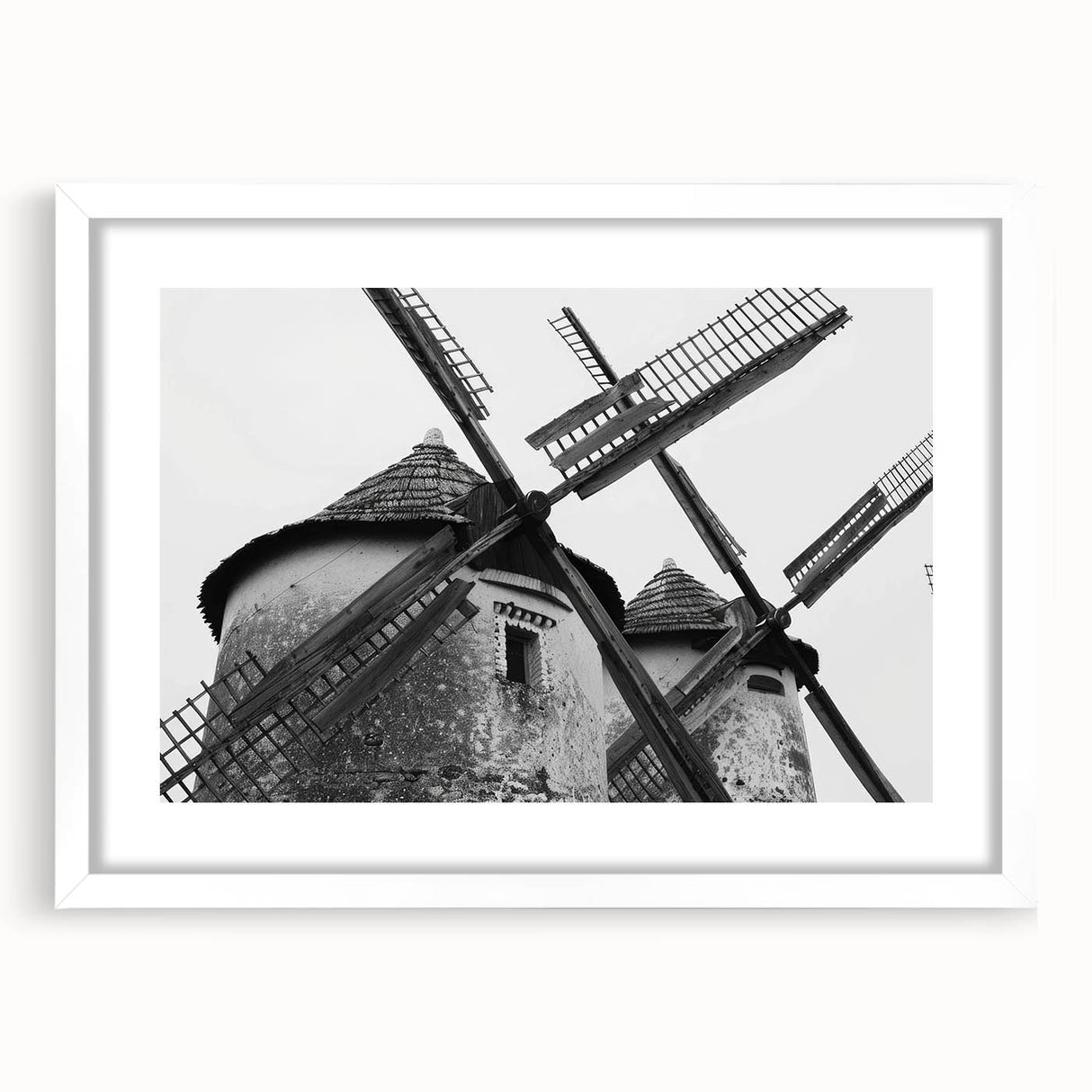 Framed wall art featuring a serene landscape scene with windmills, presented in a sleek white frame with a matte finish, ideal for home decor enhancement.