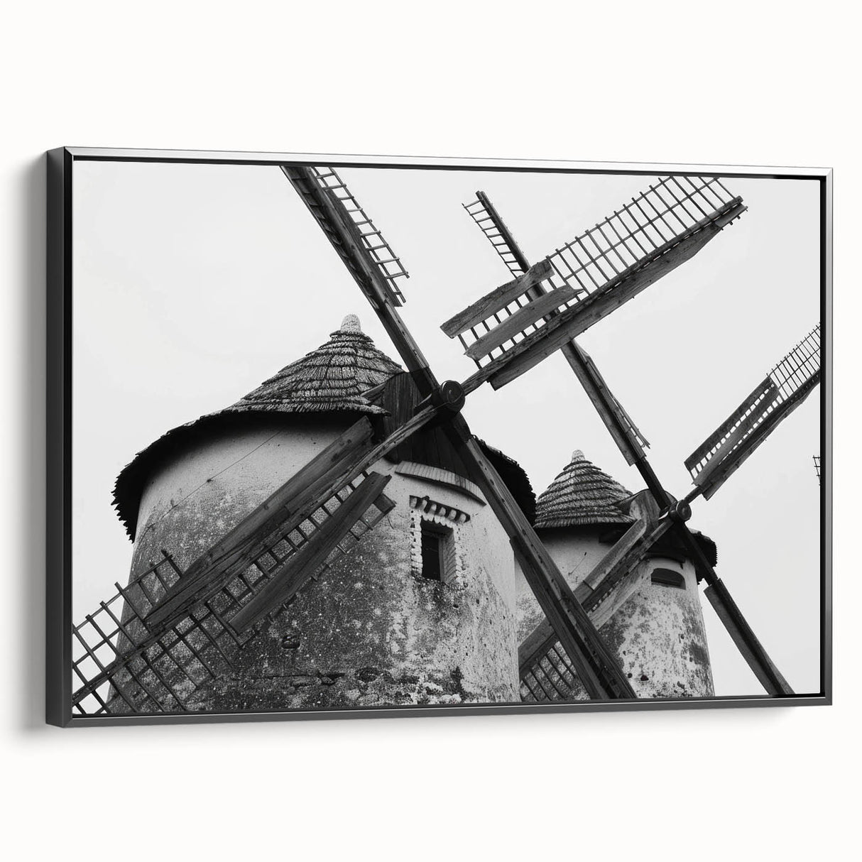 Framed canvas wall art depicting a serene landscape with windmills under a sunset sky, featuring a sleek black frame, ideal for modern home décor.