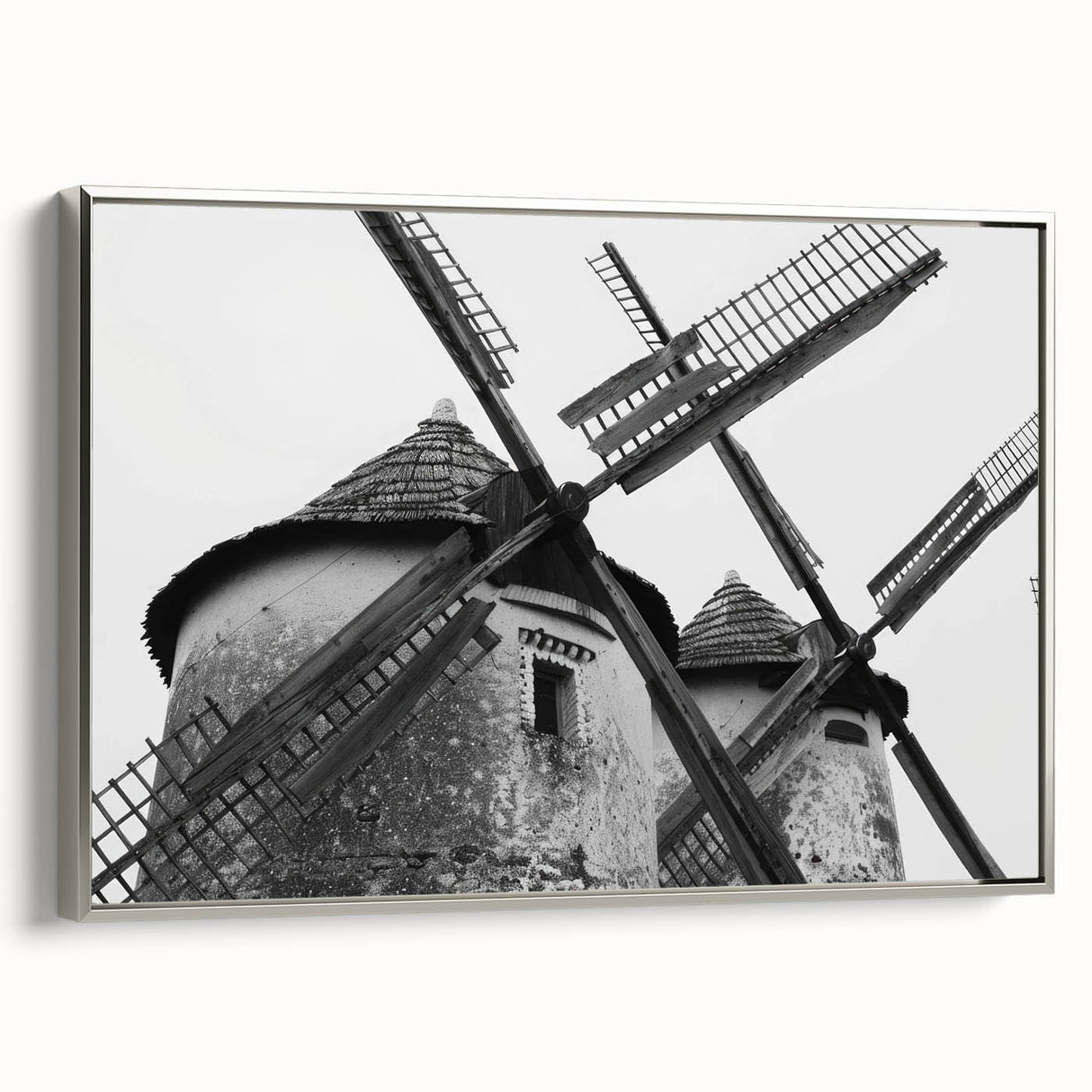 Framed canvas wall art showcasing a serene landscape with windmills, highlighted by silver framing and a contemporary design, perfect for modern home decor.