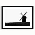 Framed wall art showcasing a serene landscape with windmills, featuring a sleek black frame and white matting, perfect for enhancing home decor aesthetics.
