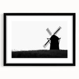 Framed wall art showcasing a serene landscape with windmills, featuring a sleek black frame and white matting, perfect for enhancing home decor aesthetics.