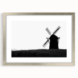 Framed wall art showcasing a picturesque landscape with windmills, featuring a sleek silver frame and mat, ideal for enhancing modern home decor.
