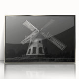 Framed wall art showcasing a serene landscape with windmills against a vibrant sunset, featuring a sleek silver frame that enhances its modern aesthetic.