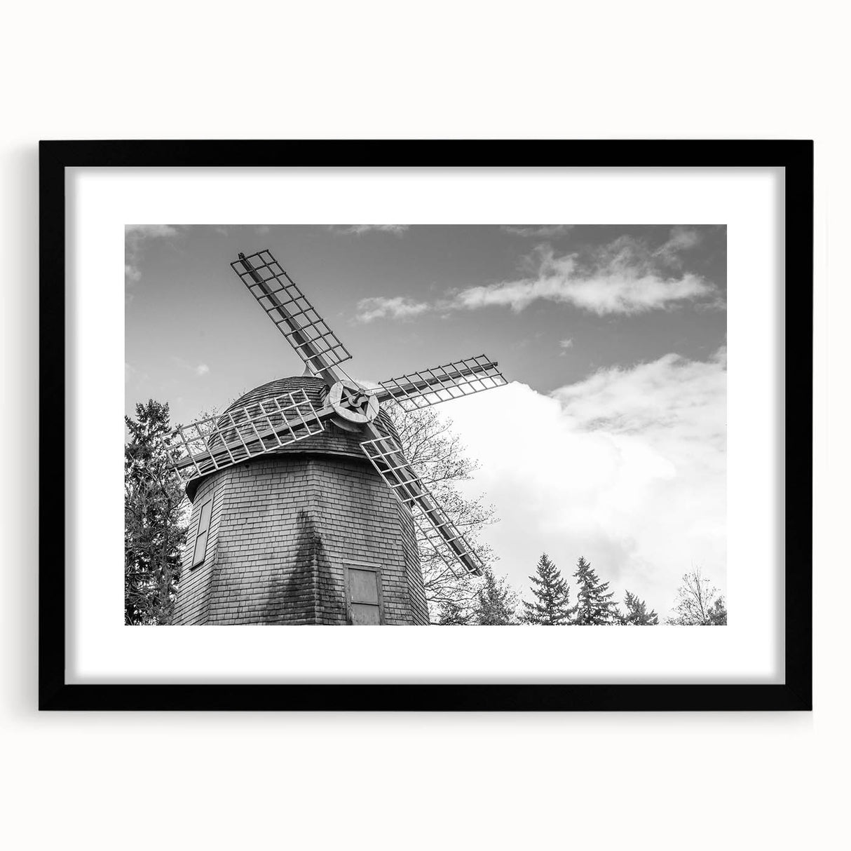 Black-framed wall art featuring a picturesque landscape with windmills, showcasing vibrant colors and intricate details, perfect for enhancing home decor.