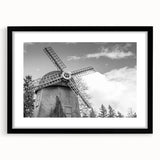 Black-framed wall art featuring a picturesque landscape with windmills, showcasing vibrant colors and intricate details, perfect for enhancing home decor.