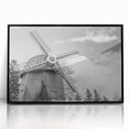 Framed wall art featuring a scenic landscape with windmills, set in a sleek black frame, showcasing vibrant colors and intricate details, ideal for home decor.