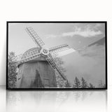 Framed wall art featuring a scenic landscape with windmills, set in a sleek black frame, showcasing vibrant colors and intricate details, ideal for home decor.