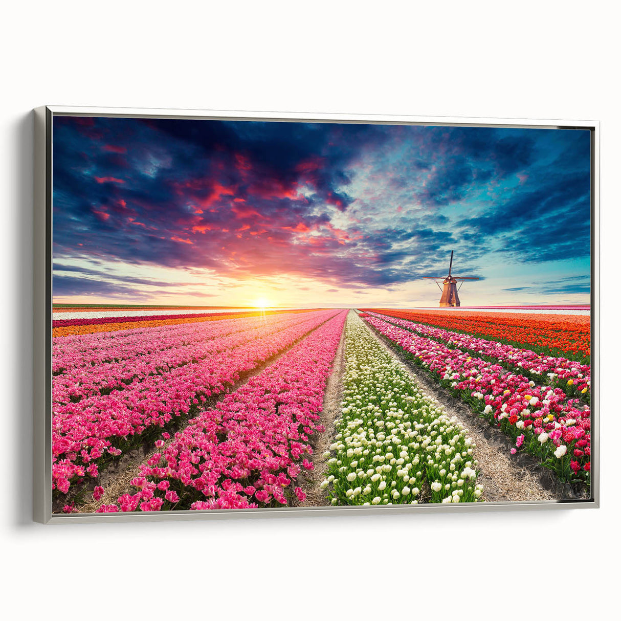 Framed canvas wall art showcasing a serene landscape with windmills, highlighted by a silver frame, perfect for modern home decor accents. The artwork captures a tranquil scene, ideal for enhancing living spaces or offices.
