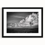 Framed wall art featuring a picturesque landscape with windmills, set against a vibrant sunset, showcasing a black frame and mat, ideal for home decor.