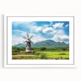Framed wall art featuring a serene landscape of windmills against a vibrant sunset, with a white matting that enhances the visual appeal, perfect for home decor.