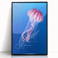 Framed wall art featuring a vibrant jellyfish design in blue and purple hues, set against a black background, perfect for marine life enthusiasts and modern home decor.