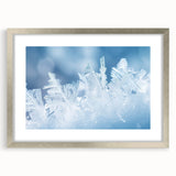 Abstract art print featuring close-up frost patterns in gray and white tones, framed in silver.