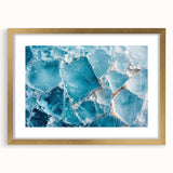 Textured art print of abstract frost patterns in icy blue and white tones, framed in gold, ideal for bedroom wall decor.