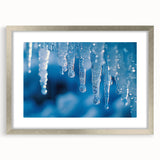 Abstract art print of frost patterns in cool blue and white tones, framed with a silver mat.