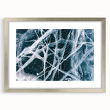 Abstract art print of frost patterns in gray and white, framed in silver, suitable for bedroom or dining room decor.