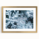Close-up textured art print of frost patterns in muted gray and white, framed in gold, ideal for bedroom art.