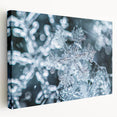 Close-up image of frost patterns on ice in muted blue and white tones on a large stretched canvas.