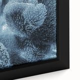 Close-up of black wall art featuring a textured frost design on framed canvas, with colorful art accents.
