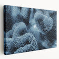 Close-up image of frost patterns on ice, rendered in muted gray and blue tones on a stretched canvas.