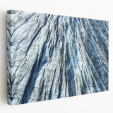 Close-up of frost patterns on ice in muted blue and white tones, printed on a large stretched canvas.