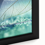 Close-up of black wall art featuring textured, colorful leaves on a framed canvas, ideal for living room decor.