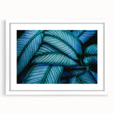 Abstract art print featuring close-up of leaves in muted green tones, framed with a white mat, ideal for dining room decor.
