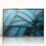 Large art print of close-up leaves in gold frame, featuring mid-century modernist style with green and gold tones.