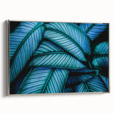 Framed canvas featuring close-up of leaves in muted green and brown tones.