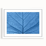Abstract art print of close-up leaves in muted green shades, framed with a white mat, ideal for bedroom or dining room decor.