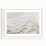 Abstract art print of close-up leaves in muted green and white, framed with a white mat.