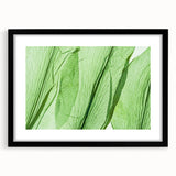 Extra large abstract art print featuring textured, colorful leaves on a canvas, framed in black, ideal for living room decor.