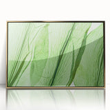 Large art print of close-up green leaves on a framed acrylic in gold, in mid-century modernist style.