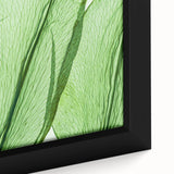 Close-up of black wall art featuring a textured leaf design in vibrant colors on a framed canvas.