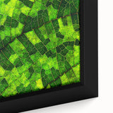 Close-up of textured leaves in vibrant green and yellow on black framed canvas, ideal for living room decor.