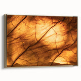Framed canvas featuring a close-up of leaves in black and gold tones, suitable as wall art for a bedroom.