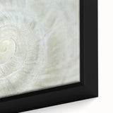 Close-up of black wall art featuring colorful, textured natural elements on a framed canvas.