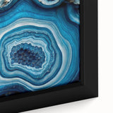 Close-up of black wall art featuring colorful, textured natural elements on a large framed canvas.