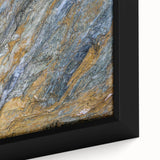 Close-up of textured black wall art featuring colorful natural elements on a large framed canvas.