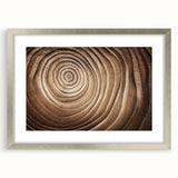 Textured art print of abstract tree designs in muted green and brown, framed in silver, ideal for bedroom wall decor.