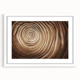 Abstract art print of close-up tree designs in muted green and brown tones on a white framed canvas.