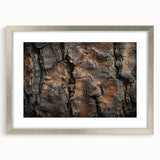 Textured art print of abstract tree designs in muted green and brown, framed in silver, ideal for bedroom art.