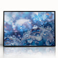 Large abstract wall art featuring swirling water patterns in blue and white, presented in a black acrylic frame.