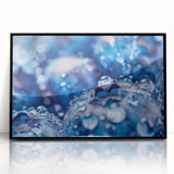 Large abstract wall art featuring swirling water patterns in blue and white, presented in a black acrylic frame.