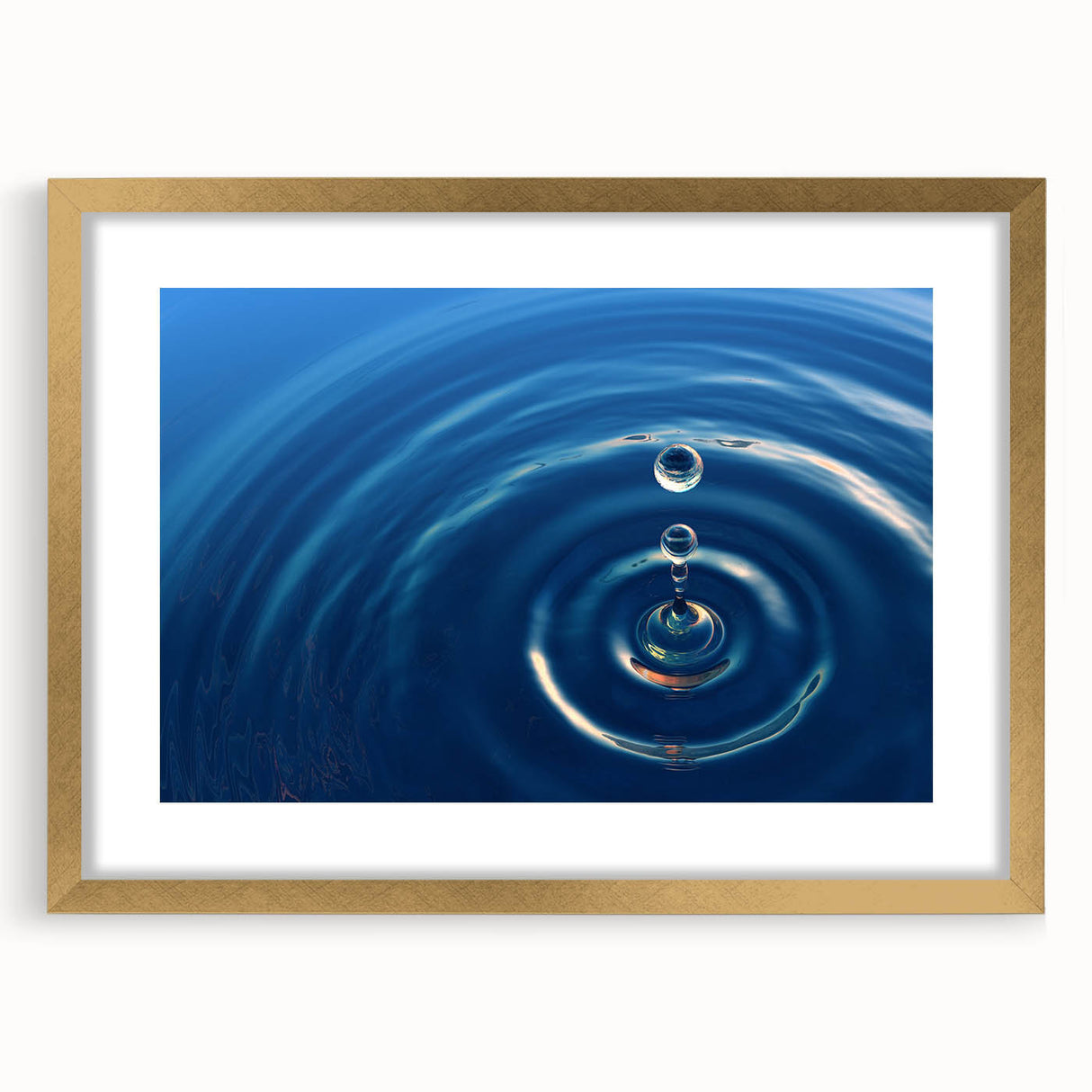 Abstract art print featuring textured water design in blue and green hues, framed in gold.