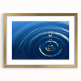 Abstract art print featuring textured water design in blue and green hues, framed in gold.