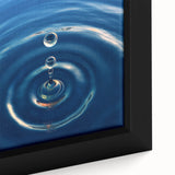 Close-up of black wall art featuring a textured, colorful water design on a framed canvas, ideal for living room decor.