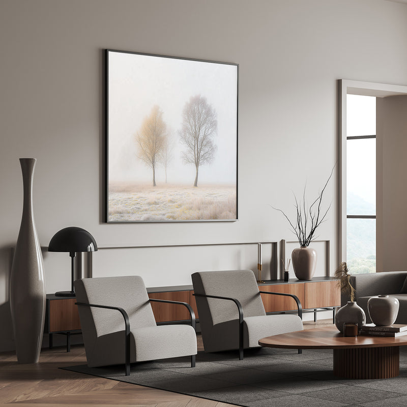 Landscape wall art with two trees in soft neutrals above dining table with wood and leather chairs


